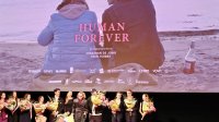 De filmposter van Human Forever en de crew op de premiere op 9 oktober in Amsterdam