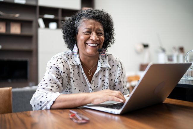Oudere vrouw werkt achter laptop