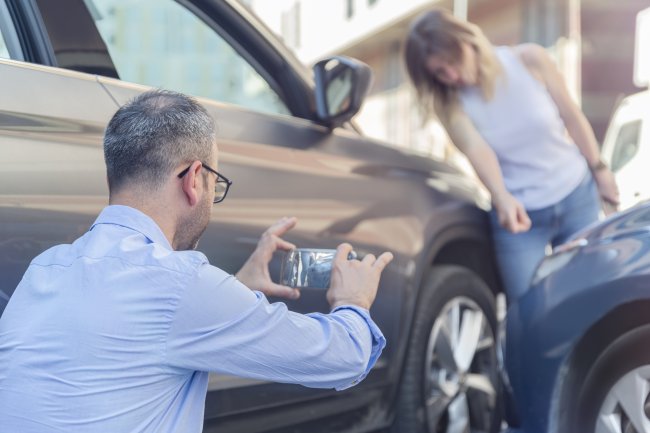 Schadeformulier man maakt foto van verkeersongeluk