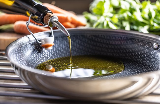 Olijfolie wordt in de pan gegoten