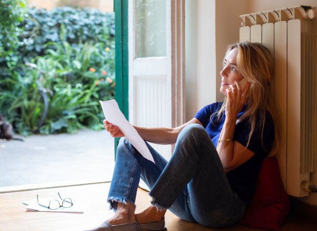 Vrouw aan de telefoon met de tuindeur open