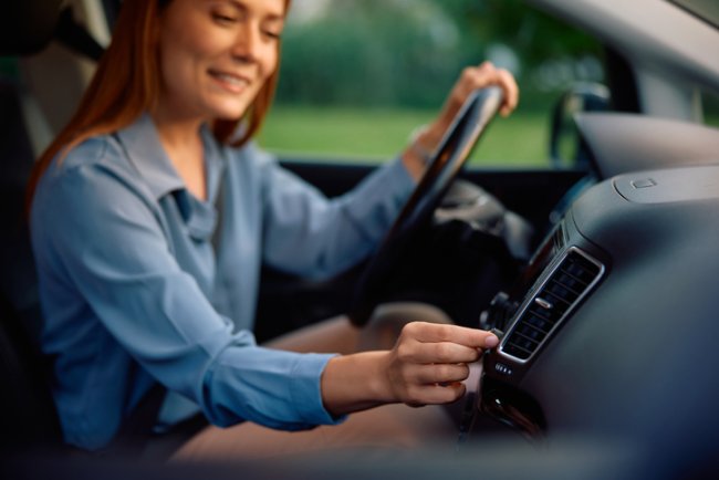 Airco van de auto, vrouw past de sterkte aan