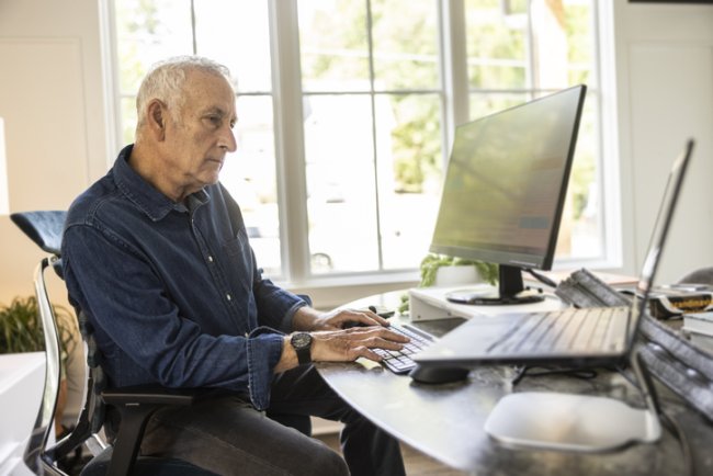 Oudere man achter laptop