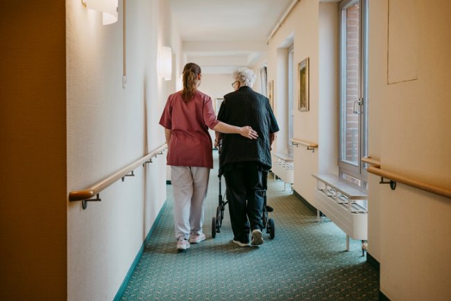 Man en verpleegster van achteren in verpleeghuis