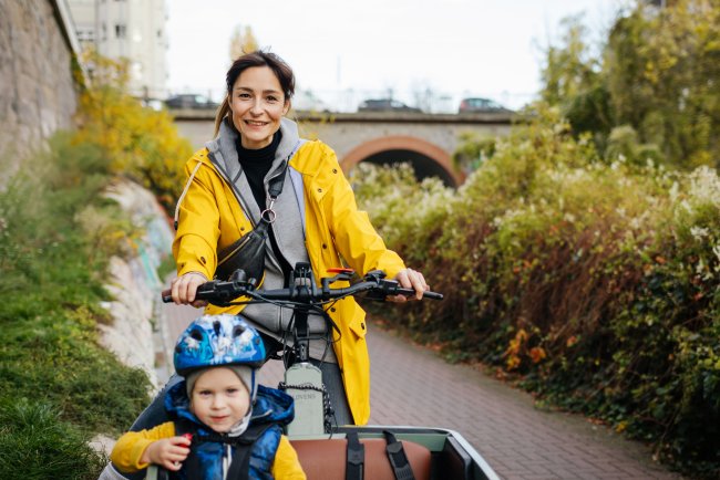 Vrouw met regenjas op fiets