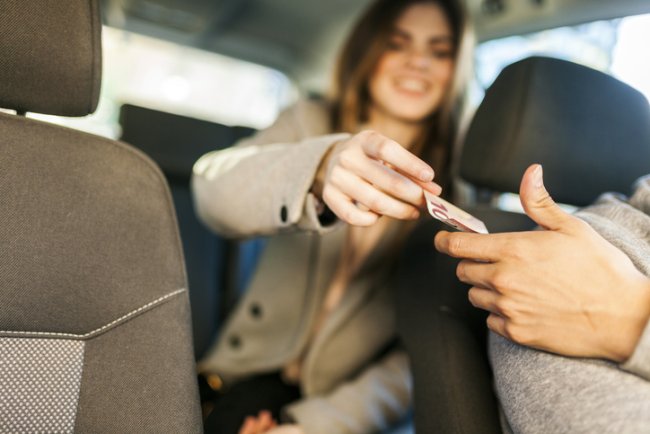 Vrouw zit met geld in de auto