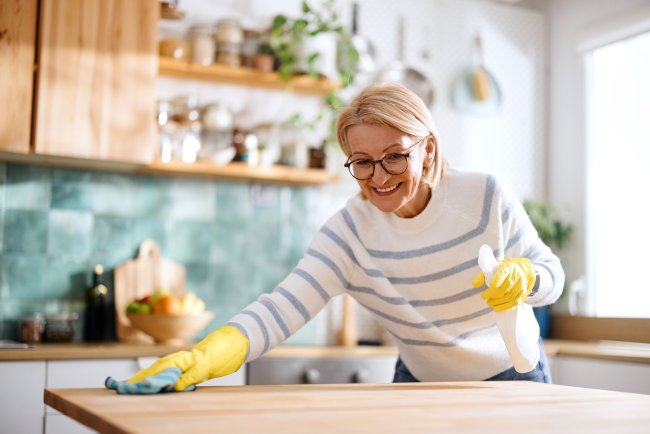 Oudere vrouw maakt uitgebreid keuken schoon