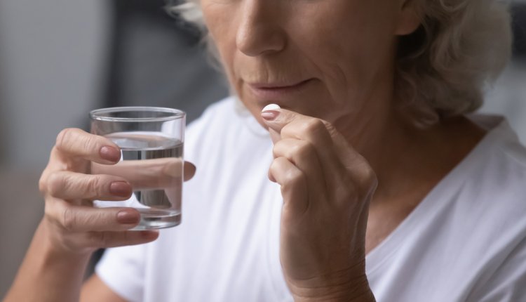 Vrouw slikt pijnstiller