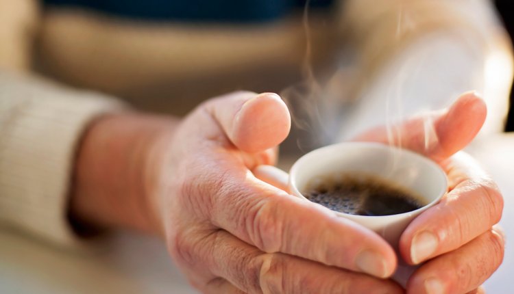 Vrouw warmt handen aan koffie