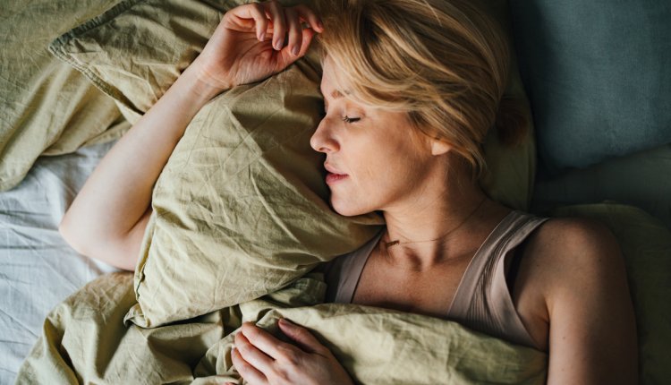 vrouw slaapt op haar zij in bed