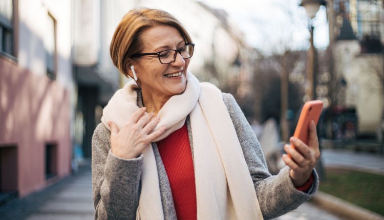 Vrouw met bril en telefoon op straat