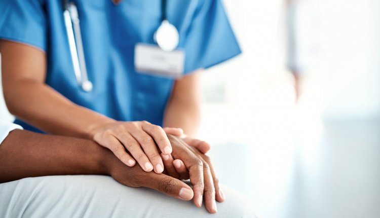 Verpleegkundige houdt hand vast van patiënt