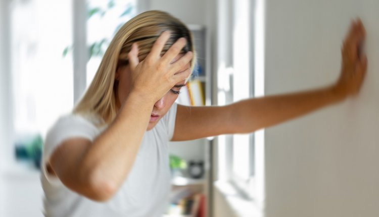 Vrouw met hoofdpijn grijpt haar hoofd vast