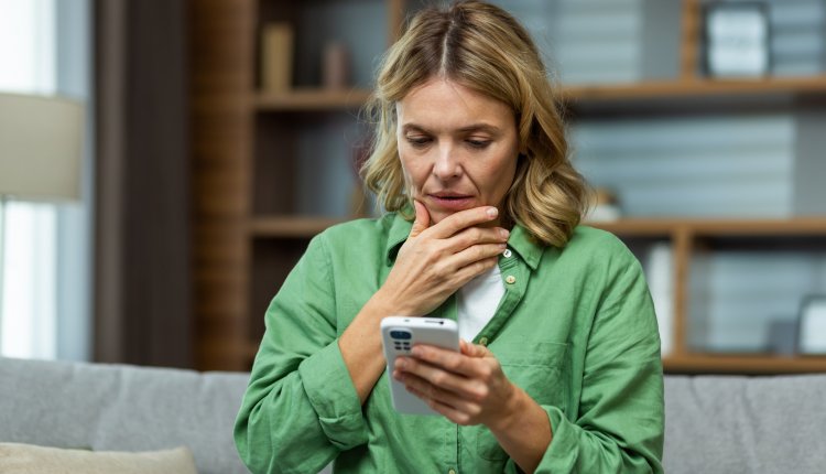 Vrouw kijkt bezorgd op haar telefoon