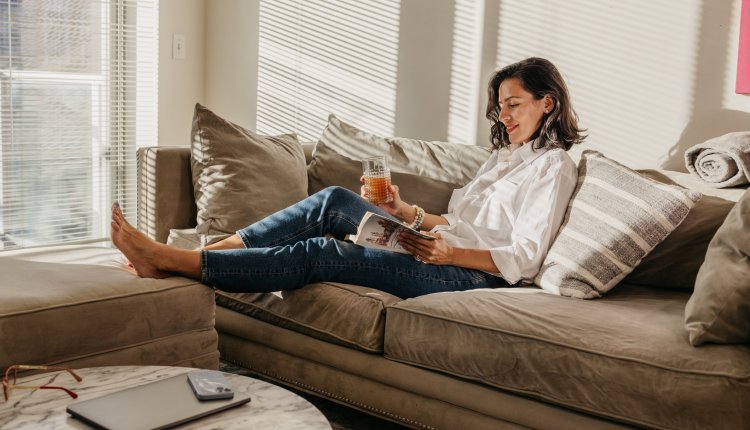 Boekenweek knappe vrouw leest rustig een boek op de bank