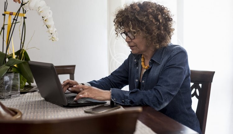 Vrouw met laptop in de woonkamer