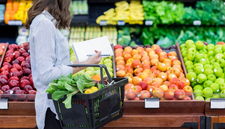 Vrouw op de groente en fruit afdeling in de supermarkt
