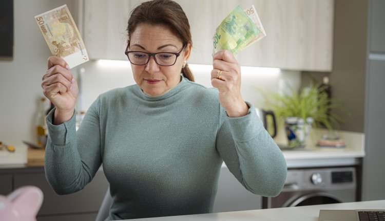 Vrouw met bankbiljetten in de hand controleert status van haar hypotheek