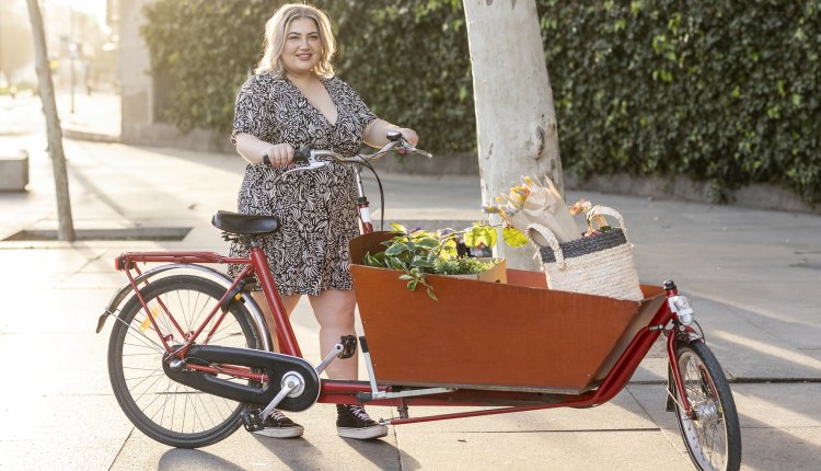 Vrouw met volgeladen fiets met boodschappen