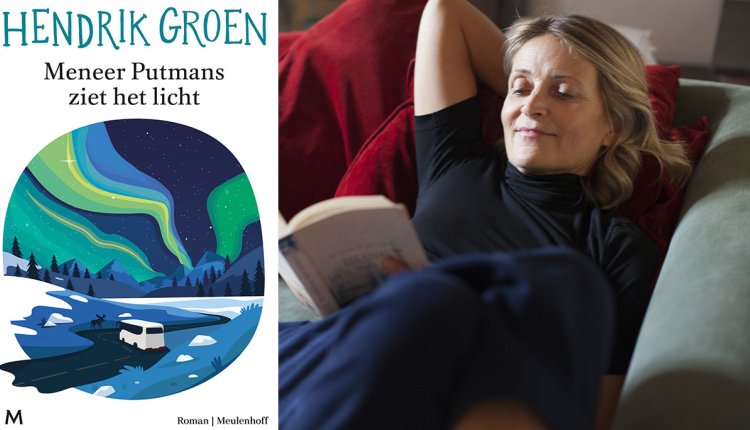 Vrouw leest op de bank een boek van Hendrik Groen