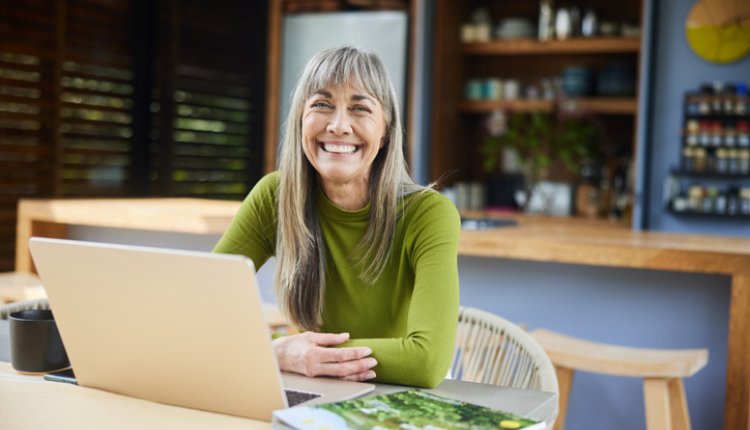 Vrouw zit achter haar laptop te werken