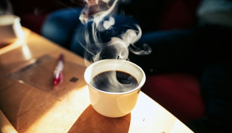 Een kop koffie op tafel in de zon