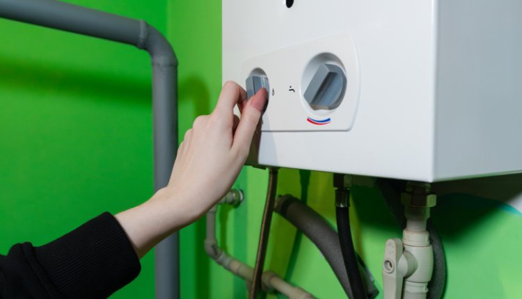 CV ketel met vrouwenhand aan de knop