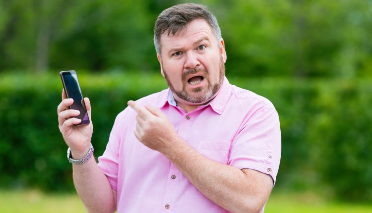 Man is boos en verongelijkt aan de telefoon in de tuin