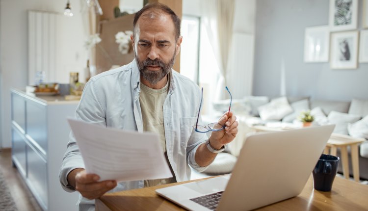 Man is bezig met zakelijke papierwinkel in huiskamer