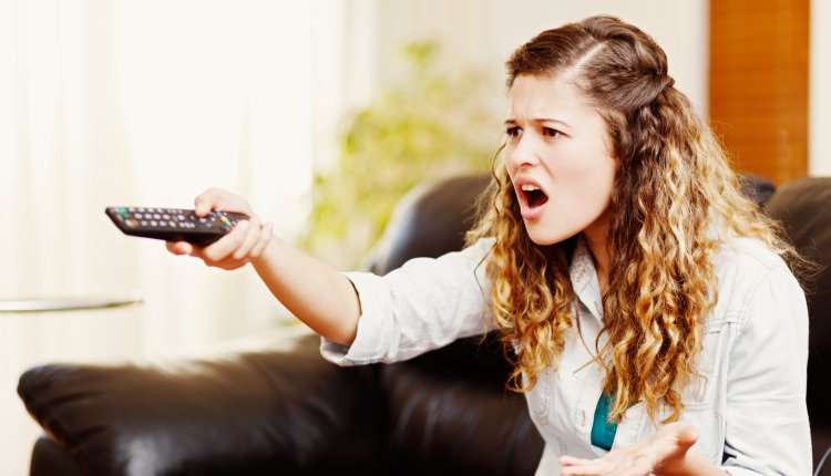 Vrouw is aan het zappen op televisie