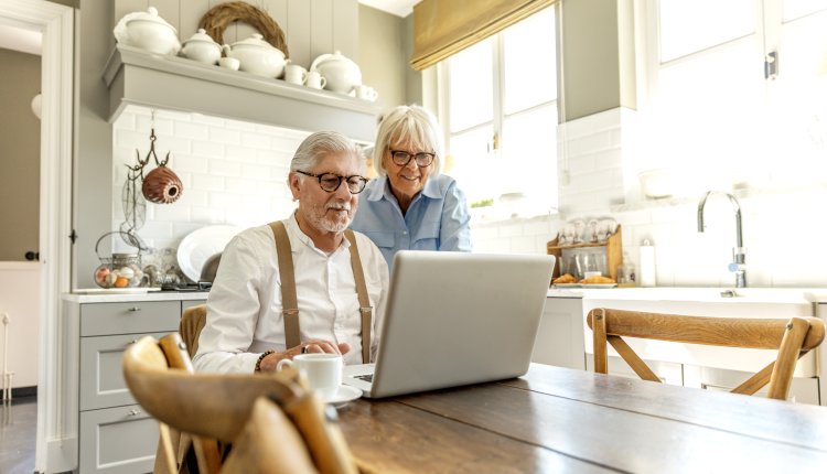 ouder stel aan tafel met computer