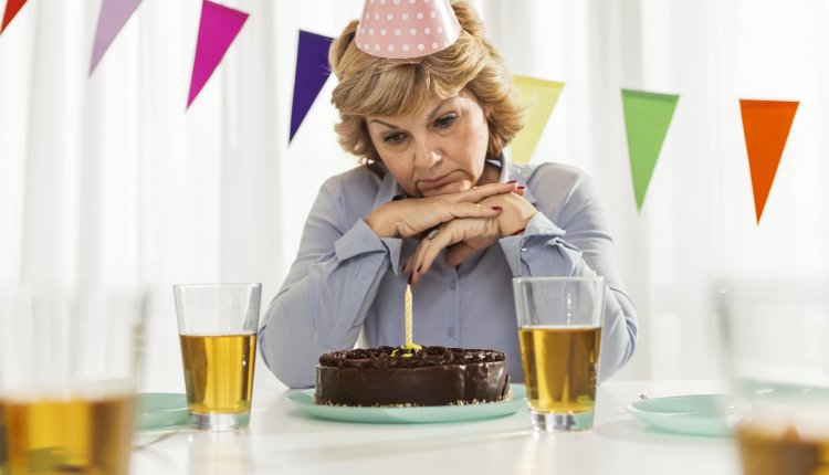 Vrouw viert verjaardag alleen met chocoladetaart, sip gezicht