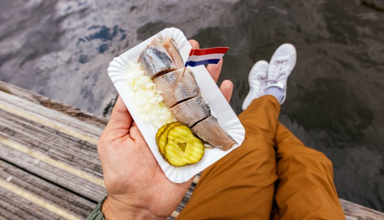 Man eet haring met uitjes en zuur