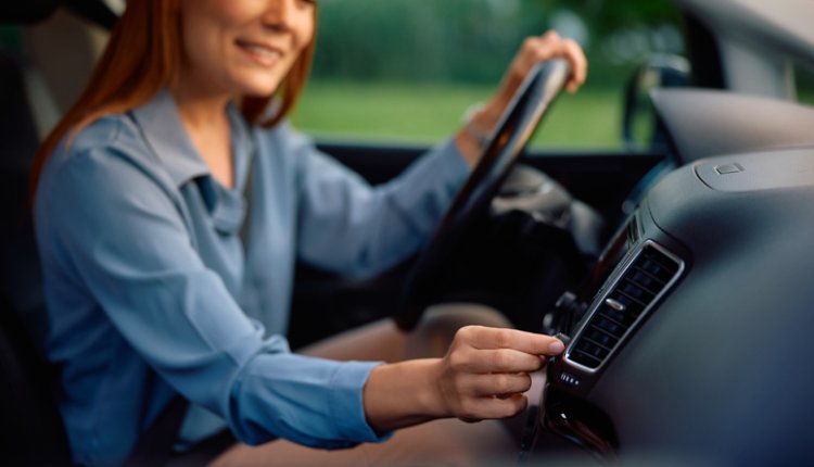 Airco van de auto, vrouw past de sterkte aan