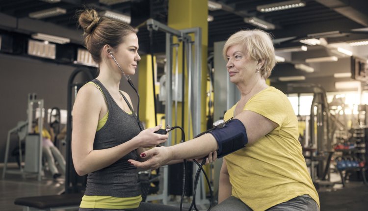 vrouw meet bloeddruk in sportschool
