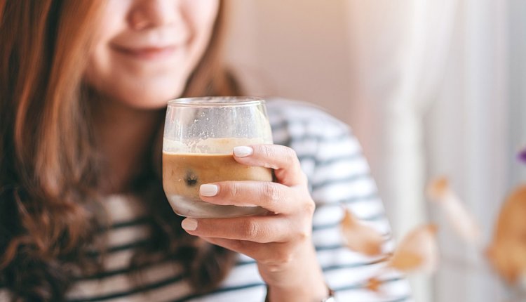 Vrouw aan een kop koffie met eiwitten