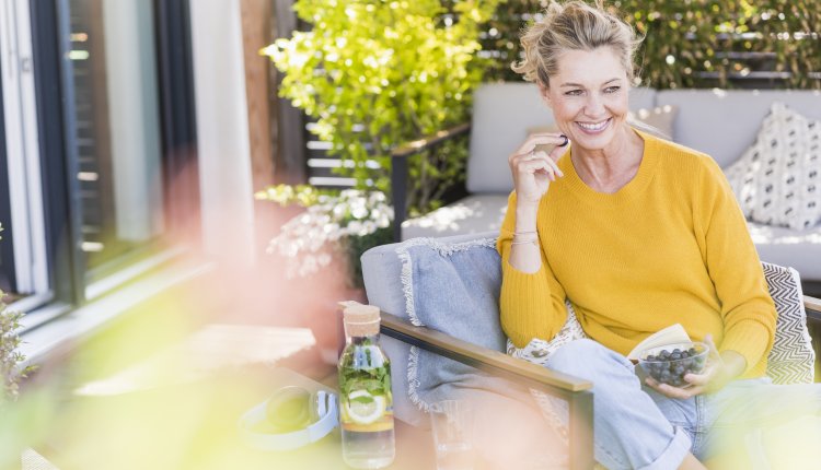 Vrouw eet op terras blauwe bessen