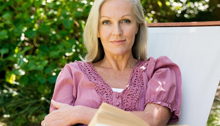 Vrouw leest boek in de tuin