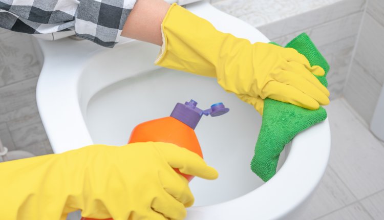Toilet schoonmaken met doek en reinigingsmiddel