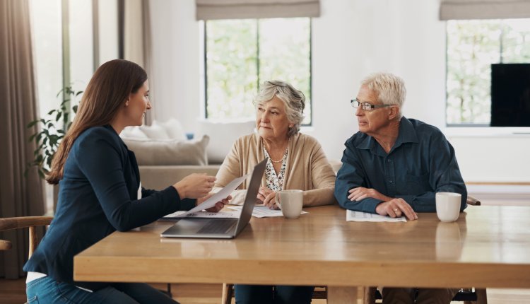 Makelaar in gesprek met senior stel aan de keukentafel
