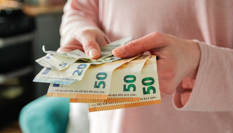 Vrouw met handen vol geldwaaier