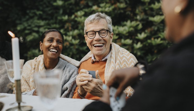 Ouderen zijn gezellig samen in de tuin aan het kaarten