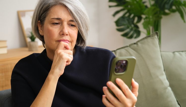 Vrouw checkt telefoon met bezorgd gezicht