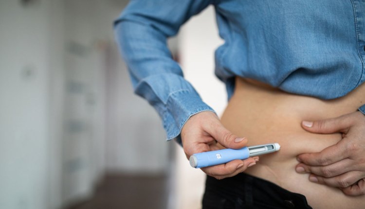 Vrouw spuit afslankmedicatie in om gewicht te verliezen