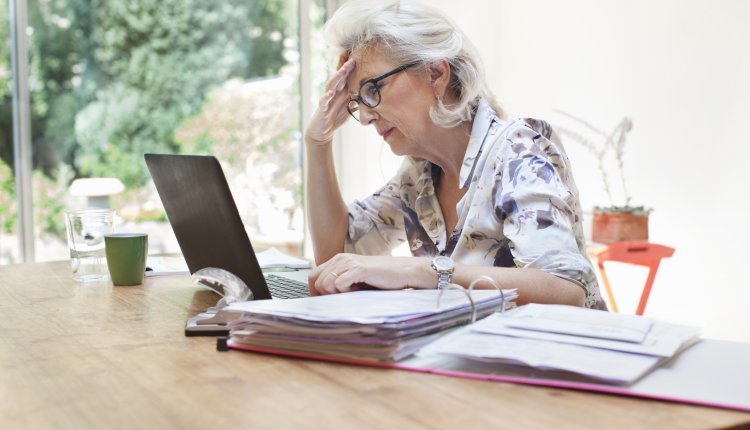 Vrouw achter laptop met zorgelijke blik