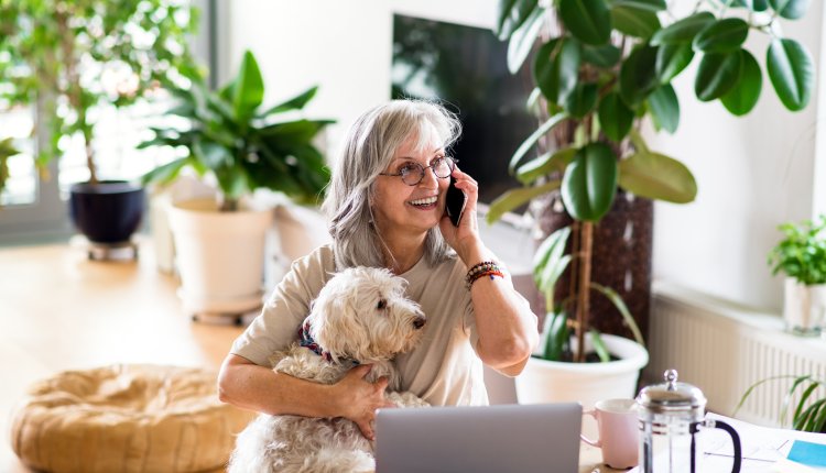 Vrouw met hond voert een vrolijke telefoongesprek