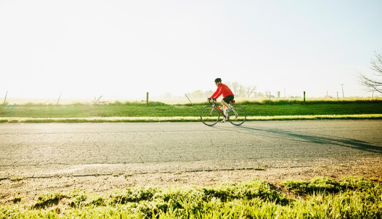 Sportieve senior aan het wielrennen op een mooie morgen