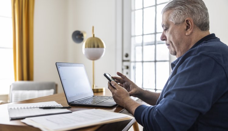 Corpulente man is thuis aan het werk achter zijn laptop
