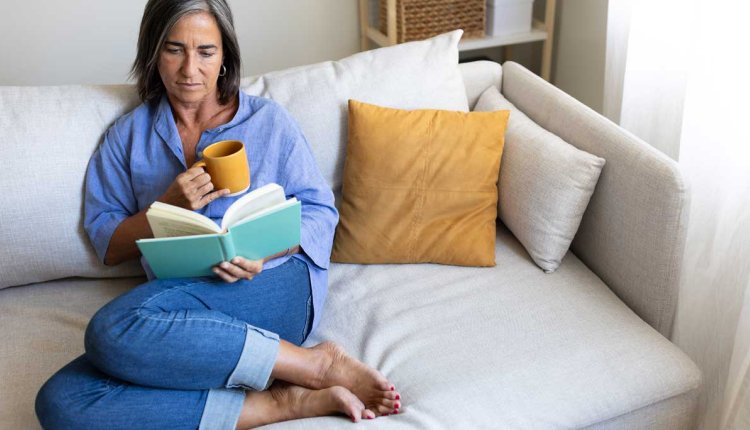 Vrouw zit op de bank te lezen