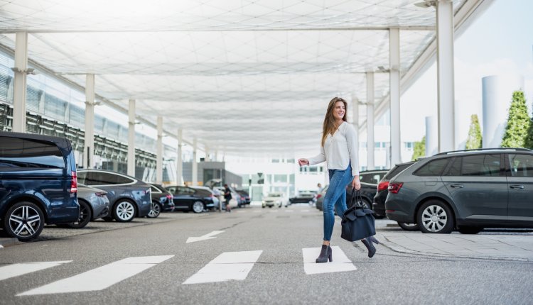 Vrouw op de parkeerplaats bij luchthaven